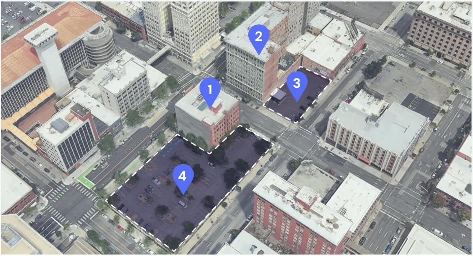 Aerial view of a downtown Spokane block with four parcels tagged: two office buildings and two surface parking lots.
